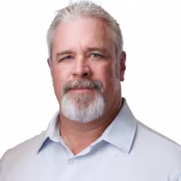 Headshot of Scott Estlund wearing light blue checkered dress shirt with white background