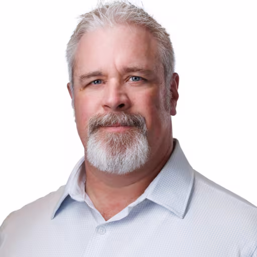 Headshot of Scott Estlund wearing light blue checkered dress shirt with white background