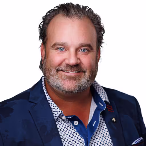 headshot of Shawn Fehily, wearing a dark blue suit with a patterned shirt