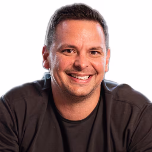 Headshot of Jeff Suter wearing black long sleeved shirt with white background