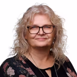 headshot of Teresa Nelson, wearing a floral blouse
