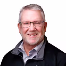 headshot of Todd Lakey, wearing a pull over with a gray shirt