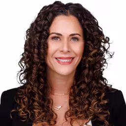 headshot of Trisha Barnes, wearing a black suit with a white blouse