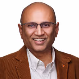 headshot of Upen Patel, wearing an orange, brown suit with a white shirt