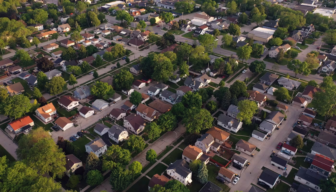 Aerial view of american suburb at summertime. Establishing shot of american neighborhood. Real estate, residential houses. Drone shot, from above