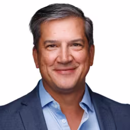 headshot of William Roseberry, wearing a dark blue suit with a light blue shirt