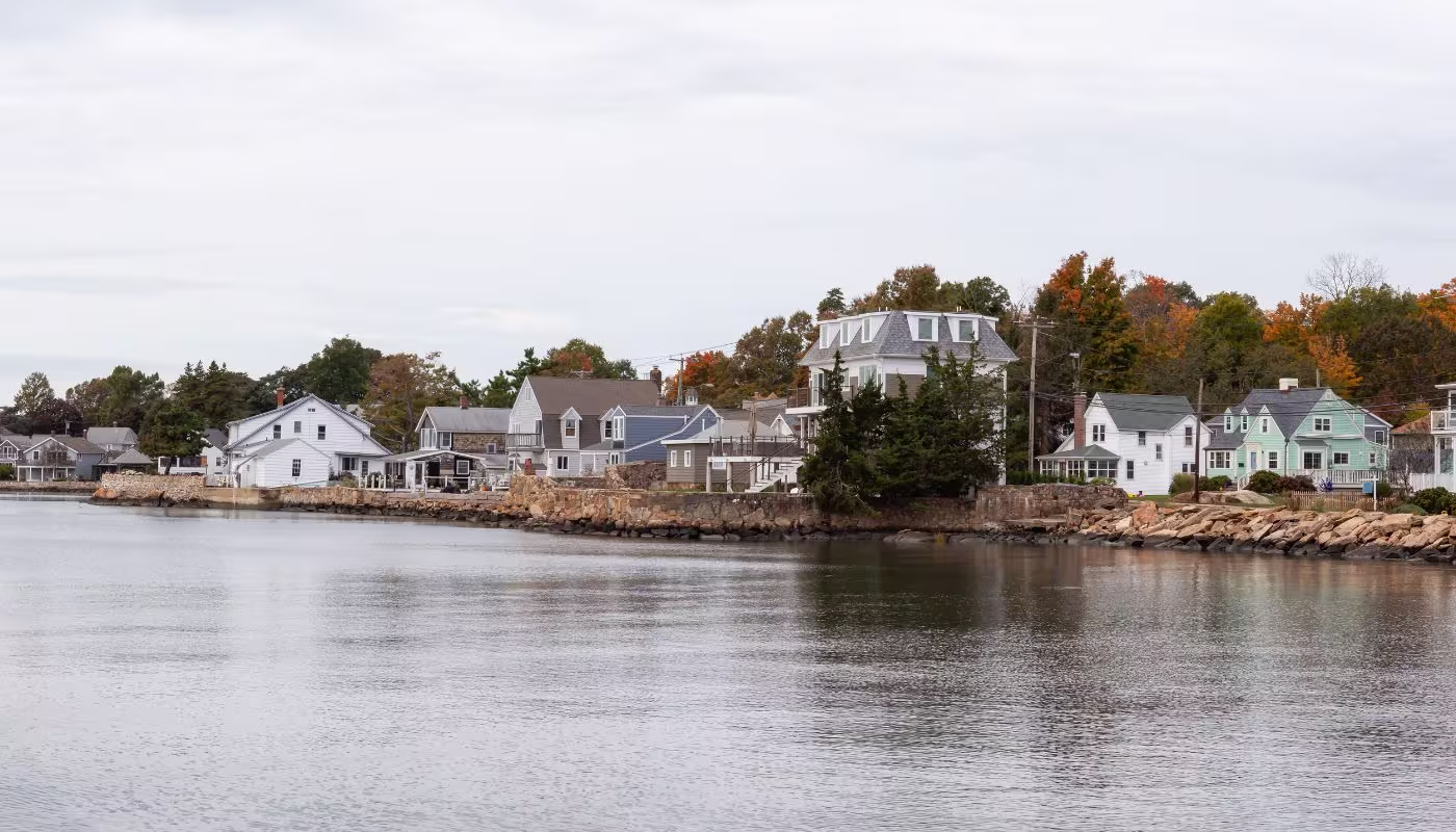 Panoramic view on residential homes on the Rocky Coast during a cloudy morning. Taken on the Atlantic Ocean in New Haven, Connecticut, United States.