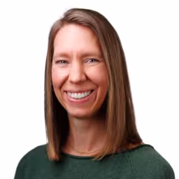 headshot of Erin Hill, wearing a green sweater