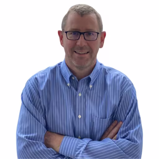 headshot of Greg Flood, wearing a blue, striped shirt