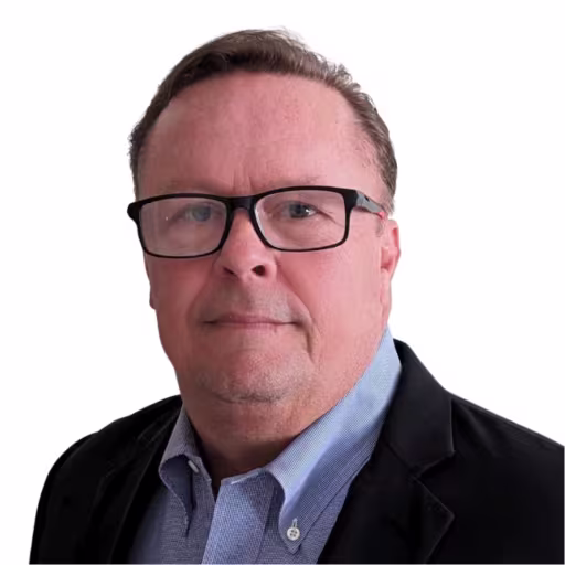 Headshot of Brendon Fray, wearing a black suit with a blue shirt