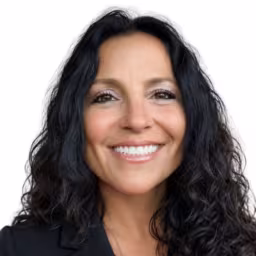 Headshot of June Ward wearing black suit coat with white background