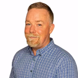 headshot of Jonathan Brooks, wearing a blue and white plaid shirt