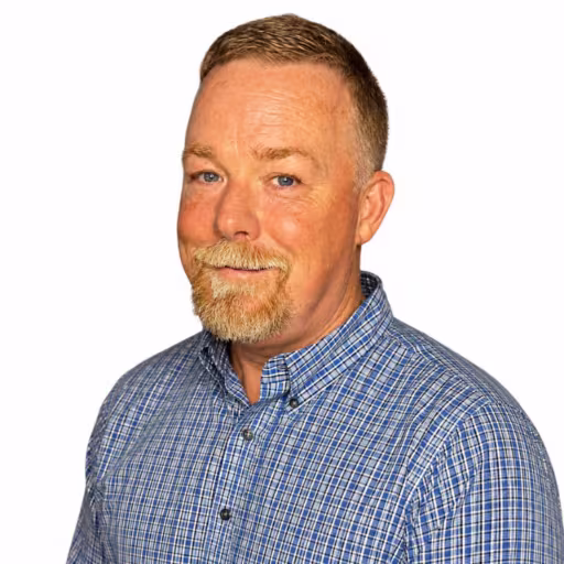 headshot of Jonathan Brooks, wearing a blue and white plaid shirt