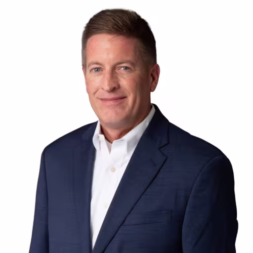 headshot of Kevin Kirk, wearing a gray suit with a white shirt