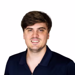 Headshot of Nathan Splant wearing dark blue collared zip up shirt with white background