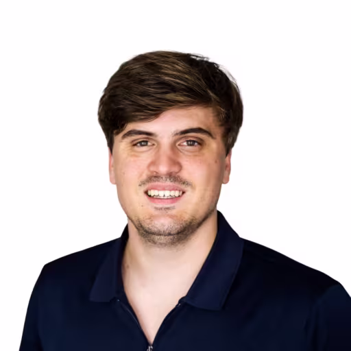 Headshot of Nathan Splant wearing dark blue collared zip up shirt with white background