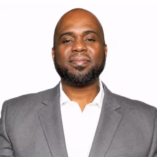 Headshot of Robert Lewis wearing white dress shirt and grey suit coat with white background