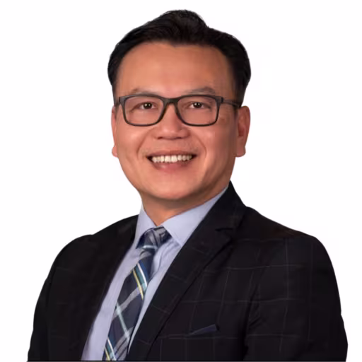 headshot of Steven Vo, wearing a black suit with a light blue shirt and blue and white stripped tie