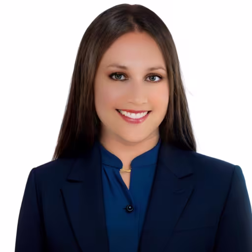 Headshot of Brittney Benjamin wearing blue button up dress shirt and blue suit coat with white background