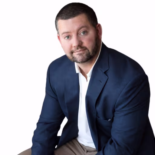 Headshot of Patrick Chicklinski wearing white button up shirt and navy blue suit coat with white background